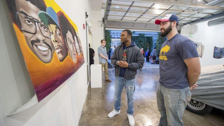 students looking at artwork on wall