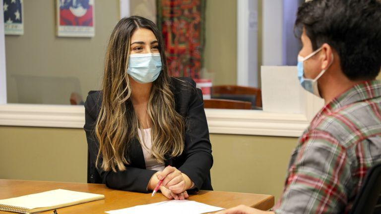 Third-year law student Flora Feizi assists a local Afghan resident filing a Humanitarian Parole application on behalf of a loved one. 