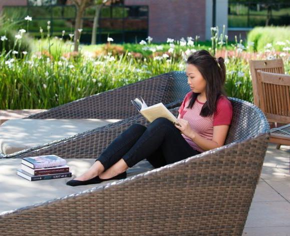 student reading in front of DeRosa Center